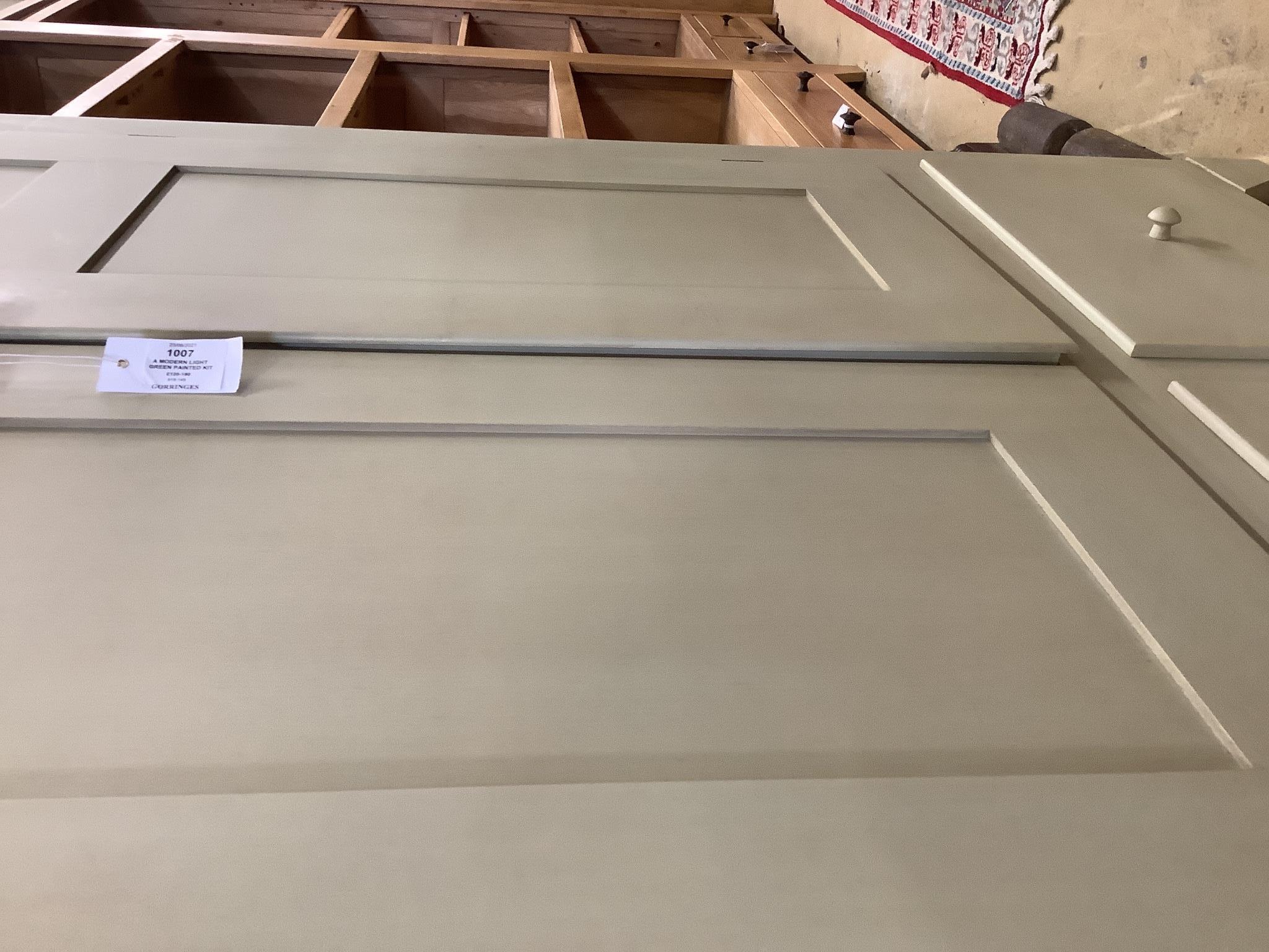 A modern light green painted kitchen cupboard, fitted shelves, racks, drawers and baskets, length 110cm, depth 51cm, height 183cm